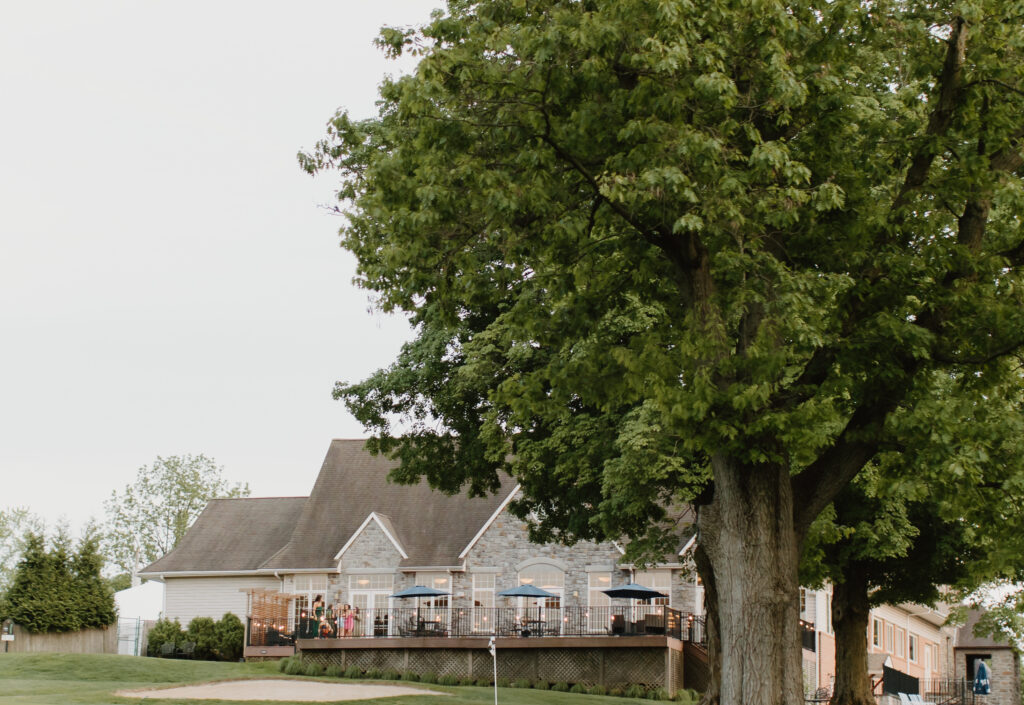 Wide exterior shot of the back of Flourtown Country Club overlooking the golf course