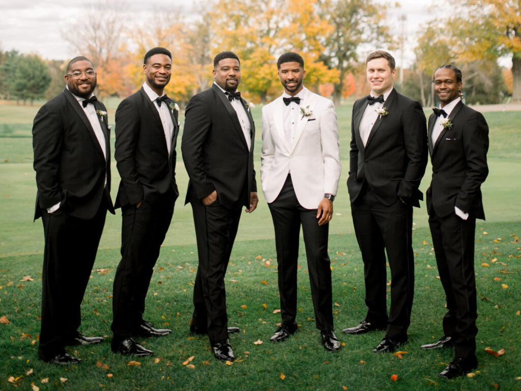 Sharply dressed groomsmen posing for a group picture at Flourtown Country Club